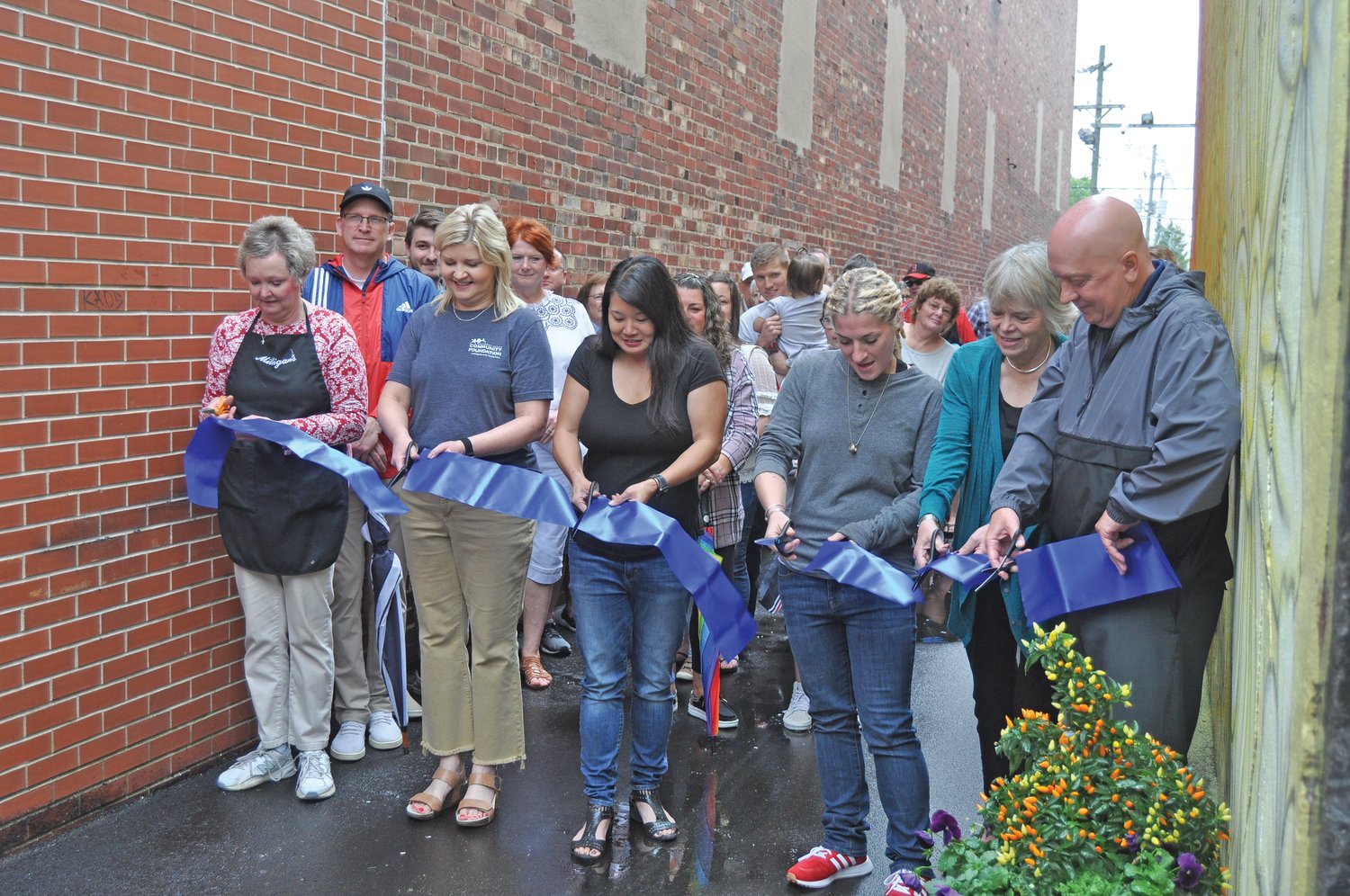 Dignitaries cut the ribbon for the new downtown Crawfordsville alley mural on Saturday.